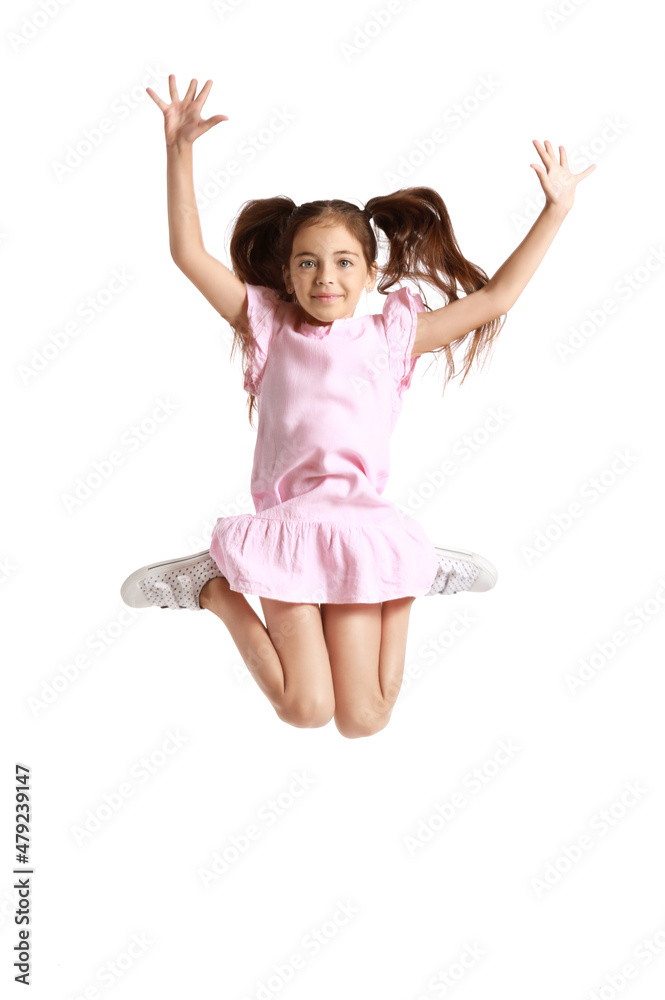 Adorable little girl in pink dress jumping on white background