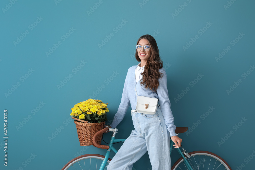 蓝色背景菊花的年轻时尚女性和自行车
