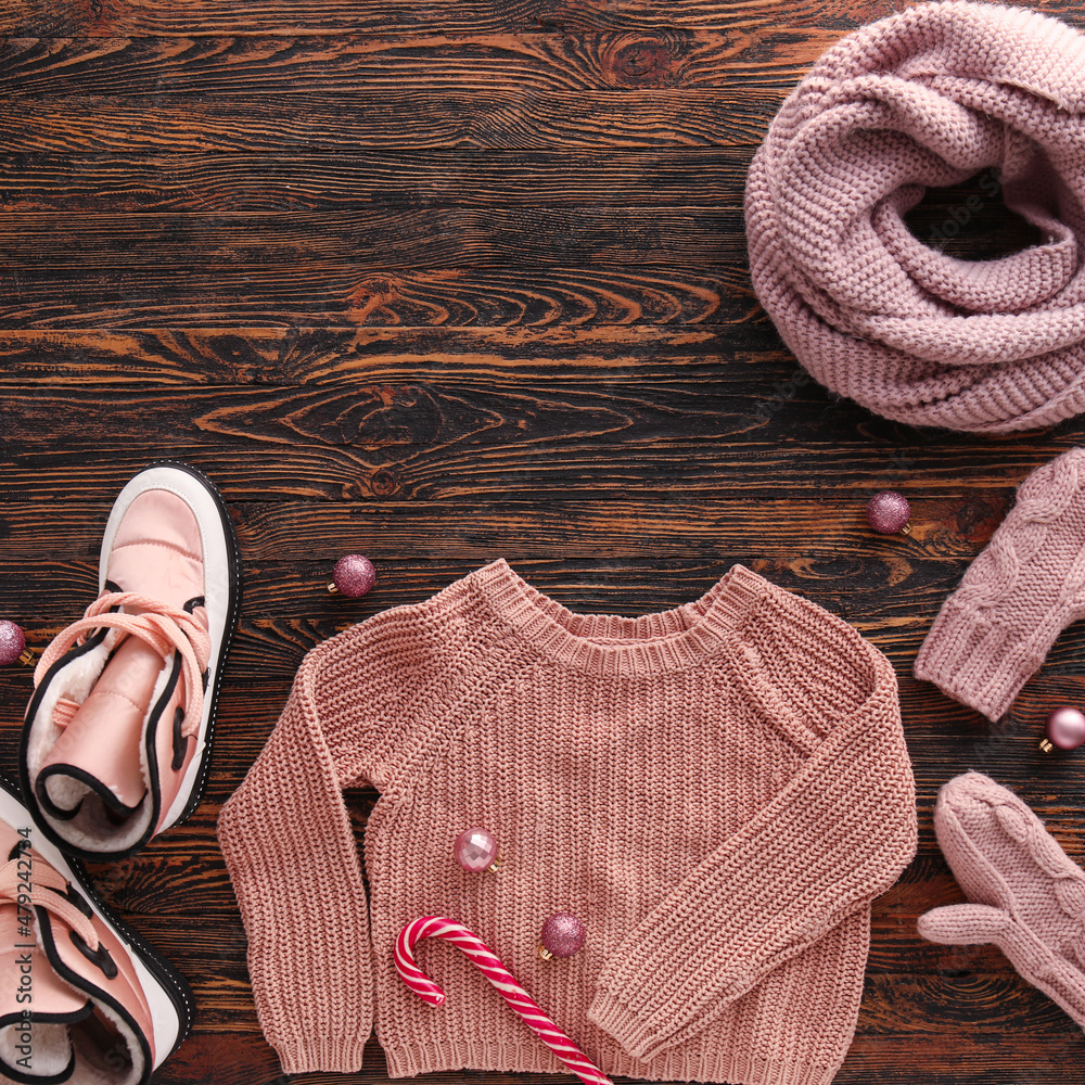 深色木质背景上的保暖衣服、鞋子和圣诞装饰