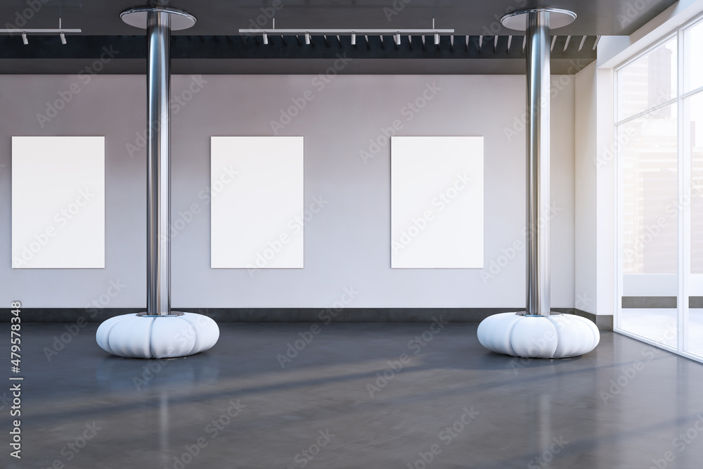 现代混凝土展厅内部，配有空的白色模型海报、装饰元素、阳光