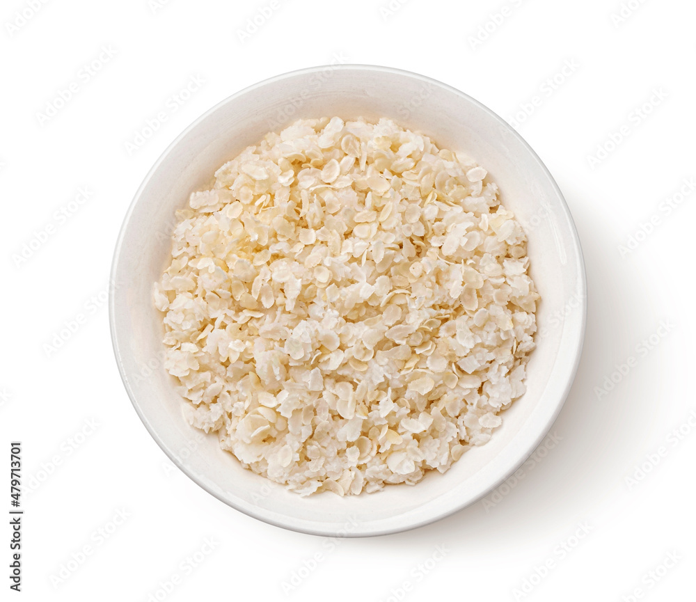 Bowl of rice flakes isolated on white background, top view