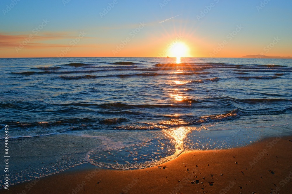 色彩斑斓的海滩日落伴着柔和的海浪