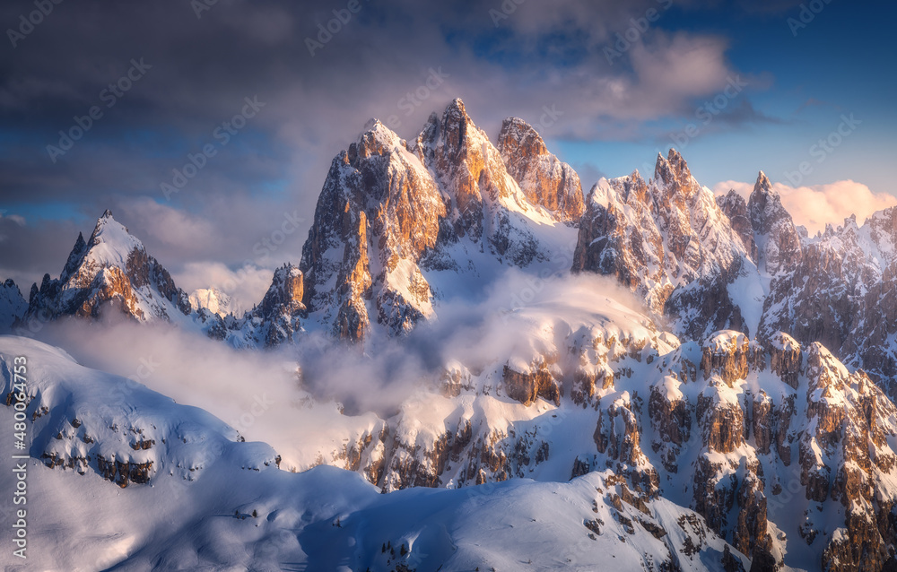 冬天日落时，美丽的山峰在雪中。f中高高的雪岩构成的多彩景观
