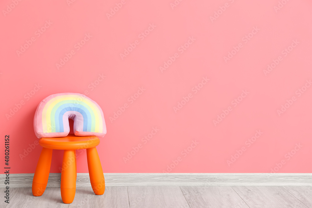 Child stool with cute toy near color wall