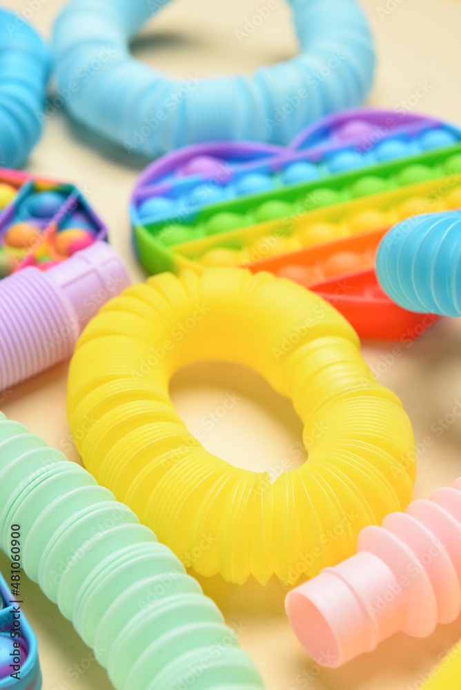 Colorful Pop Tubes and Pop it fidget toys on yellow background