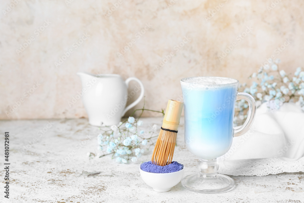 一杯蓝色抹茶拿铁，粉末和浅背景的奶油