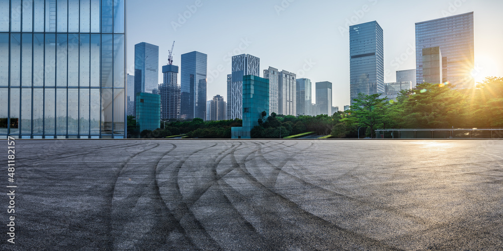 日出时，中国深圳的沥青道路和城市天际线，以及现代化的商业办公楼。