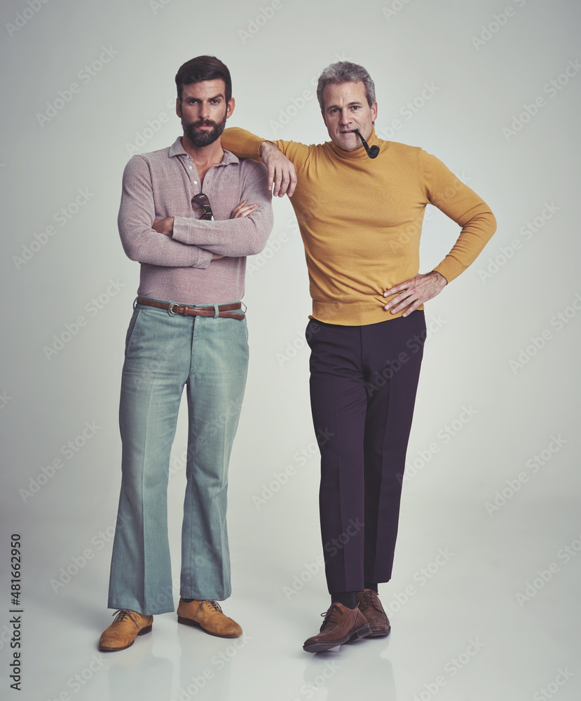 这是一个男人的世界。工作室拍摄的两个男人穿着70年代的复古服装站在一起。