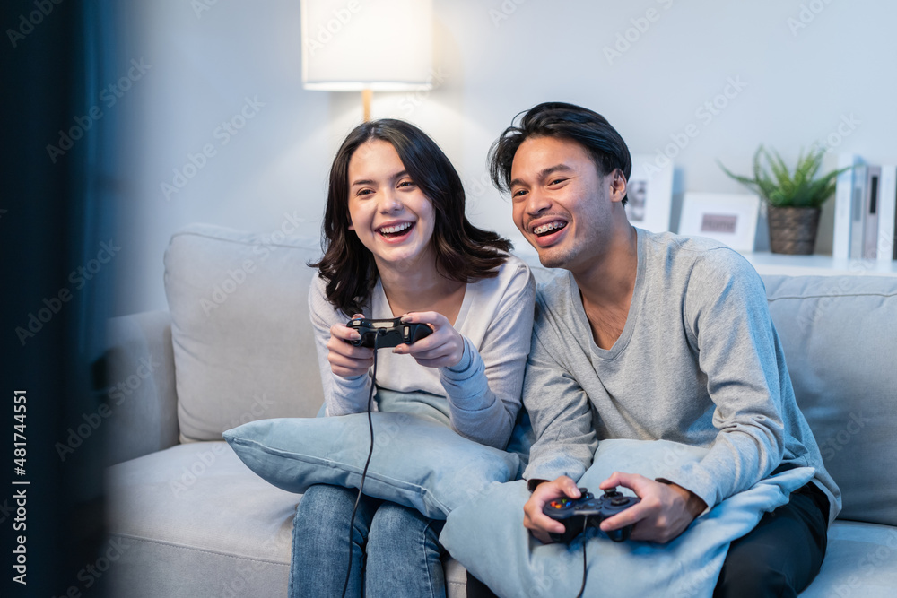 一对亚洲年轻男女喜欢在家里一起玩游戏。