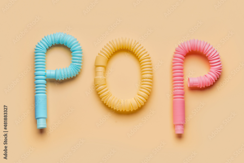 Composition with Different colorful Pop Tubes on beige background
