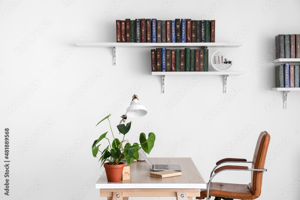 房间内部墙上挂着的书架上的桌子和书