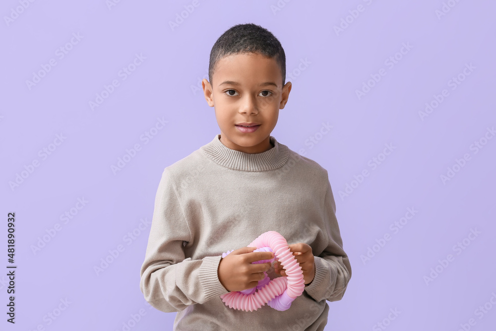 淡紫色背景下带粉色Pop Tube的非洲裔美国小男孩
