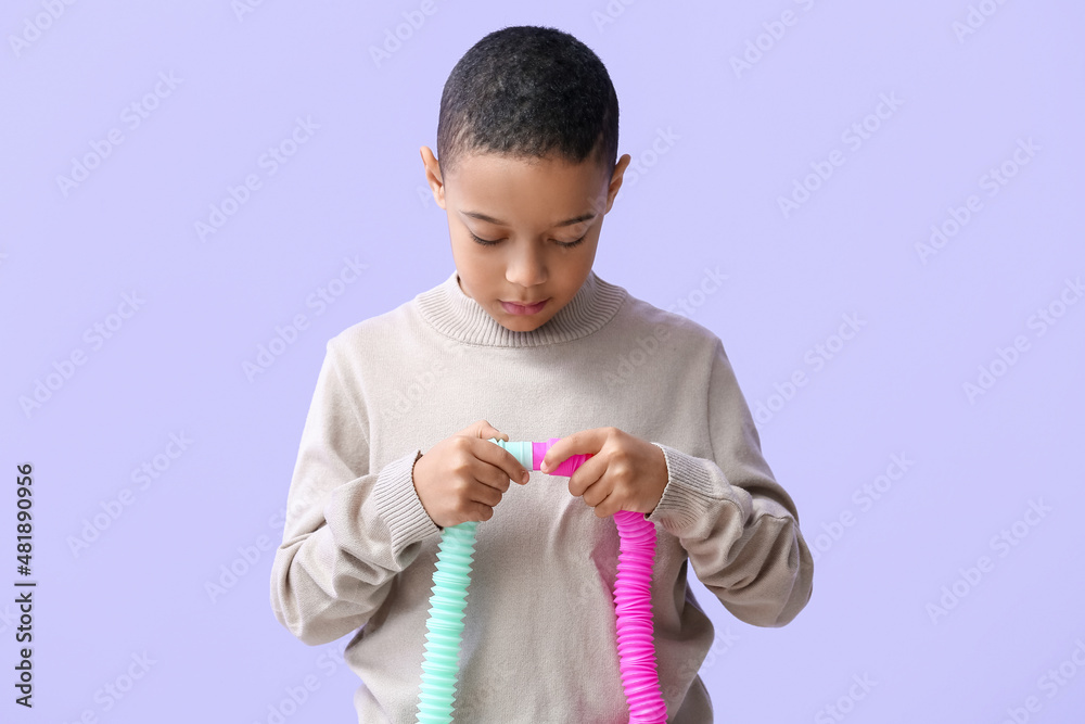 淡紫色背景下带Pop Tubes的非洲裔美国小男孩