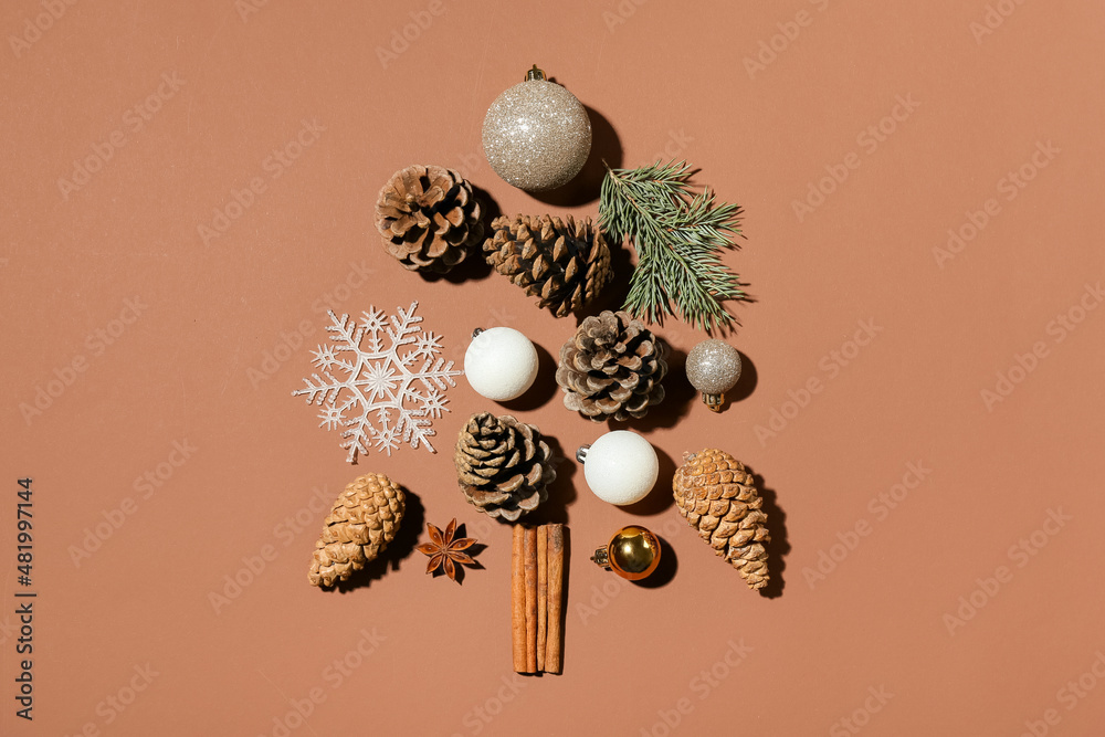 由松果、圣诞装饰和棕色背景的冷杉树枝制成的树
