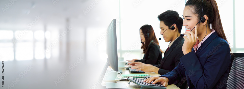 戴着耳机的商务人士在办公室工作，以支持远程客户或同事