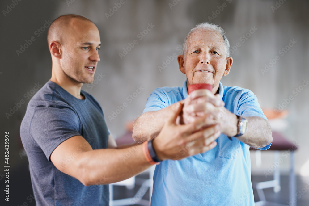 You say senior, I say strong. Shot of a senior man working out with the help of a trainer.