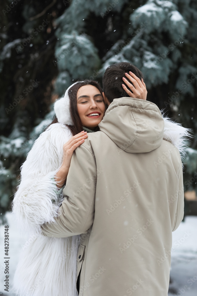 冬日雪天，一对恩爱的情侣在公园拥抱