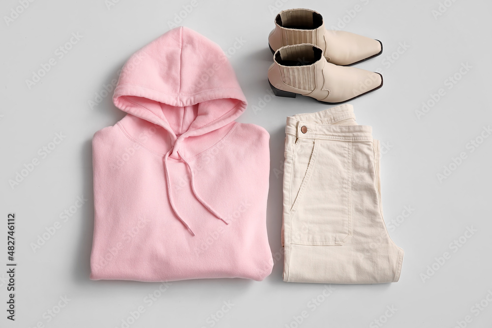 Pink hoodie with pants and shoes on light background
