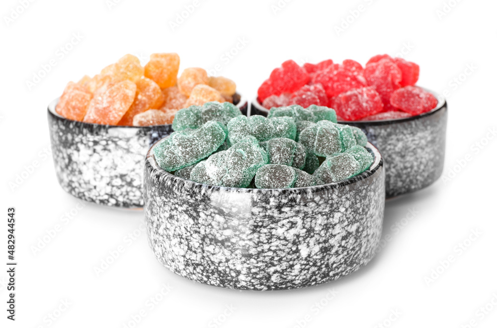 Bowls with tasty jelly bears on white background