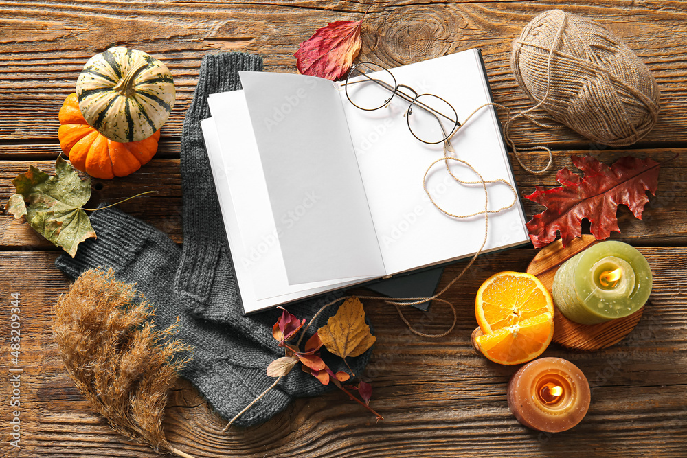 Blank book, eyeglasses and autumn decor on wooden background