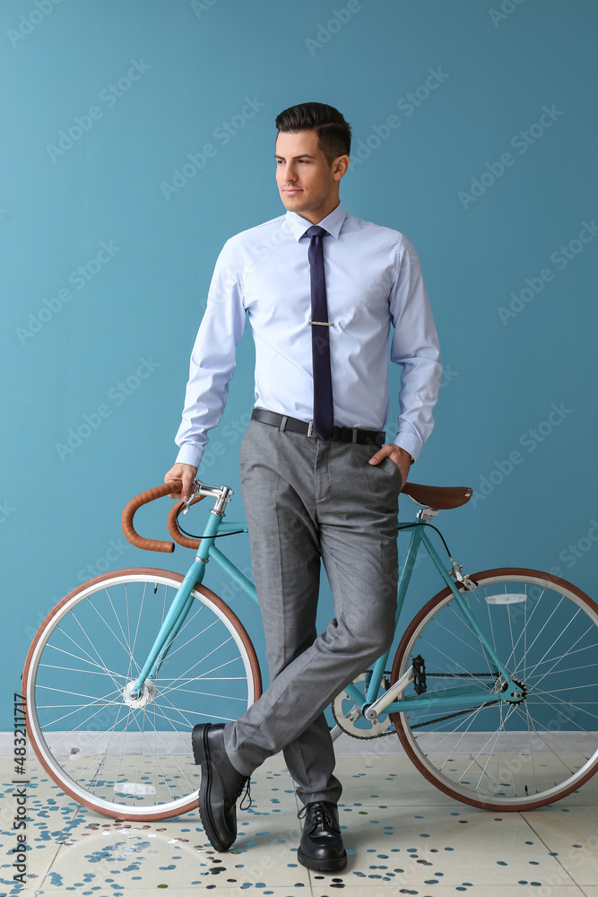 穿着正装的英俊男子，自行车靠近彩色墙