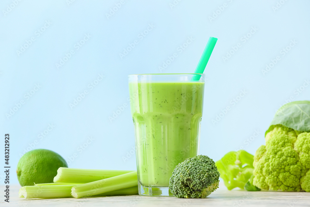 Glass of healthy green juice and fresh ingredients on table