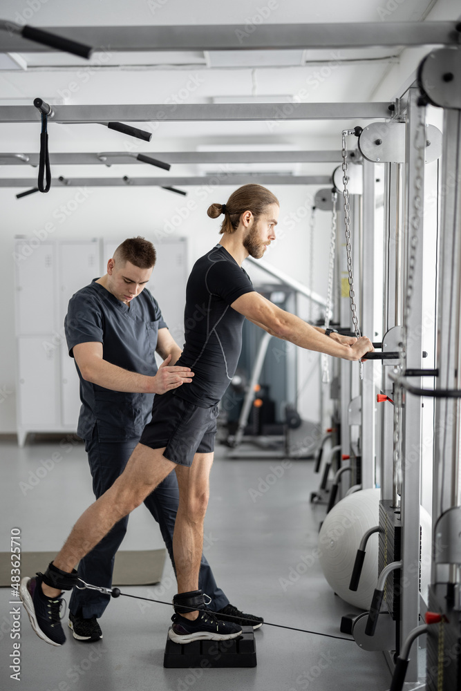 在康复专家的帮助下，男子在减压模拟器上进行锻炼。概念