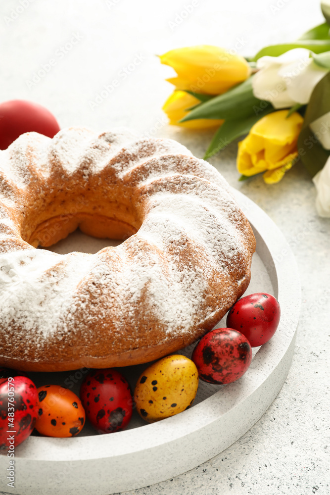 盘子里有美味的复活节蛋糕和鸡蛋，背景为浅色，特写