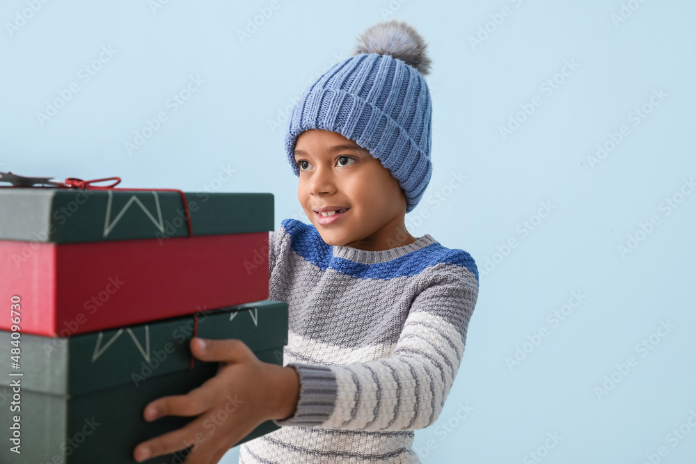 可爱的非裔美国小男孩，穿着冬装，背景是圣诞礼物