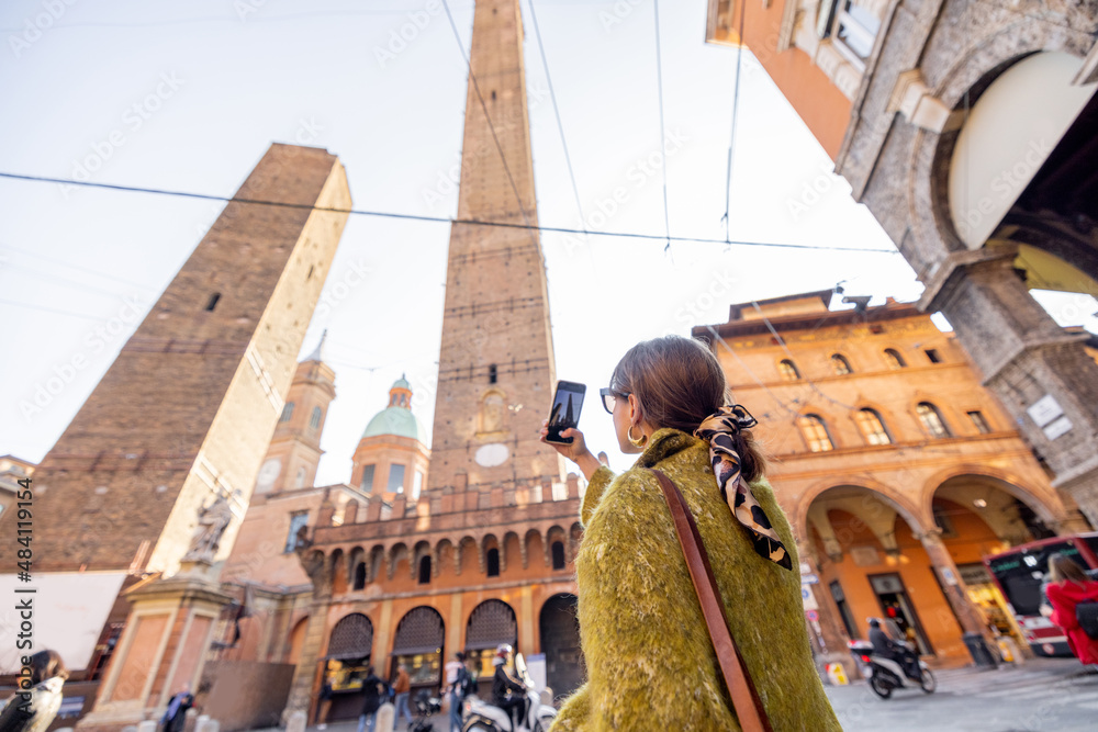 一名女子在博洛尼亚市旅行时用手机拍摄著名的阿西内利塔。视觉概念