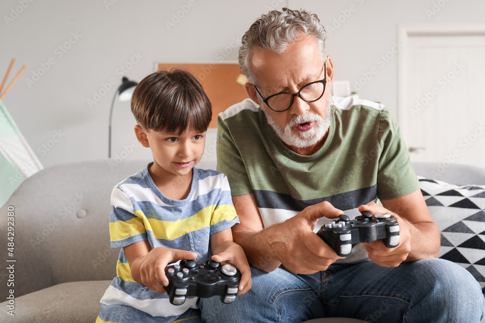 小男孩和爷爷在家玩电子游戏
