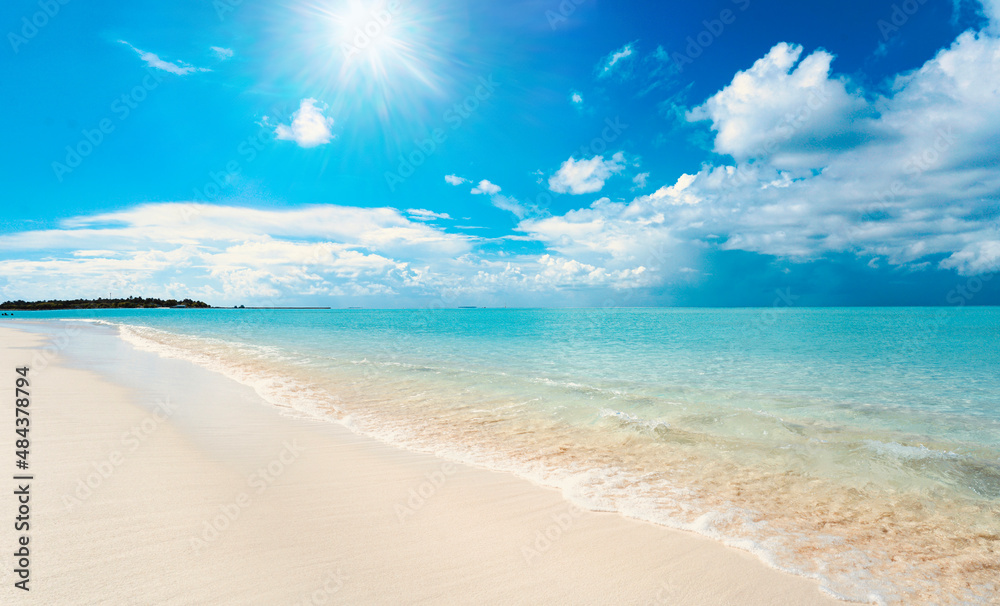 美丽的热带海滩背景图片。海洋上明亮的夏日阳光。蓝色的天空带着淡淡的clou
