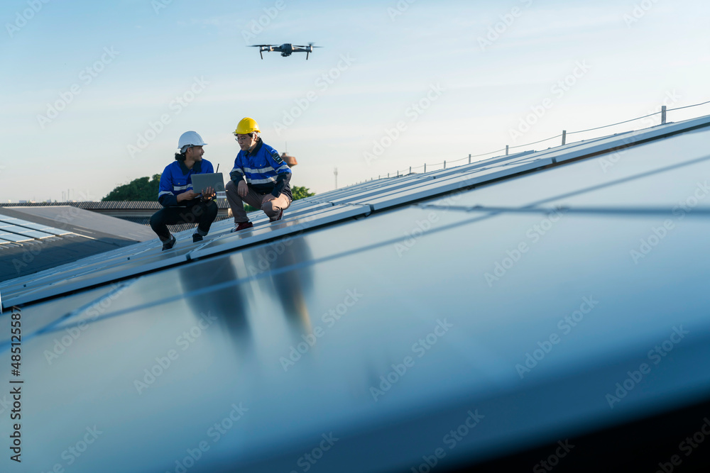 专业技术人员专业工程师控制无人机检查安装太阳能屋顶的俯视图