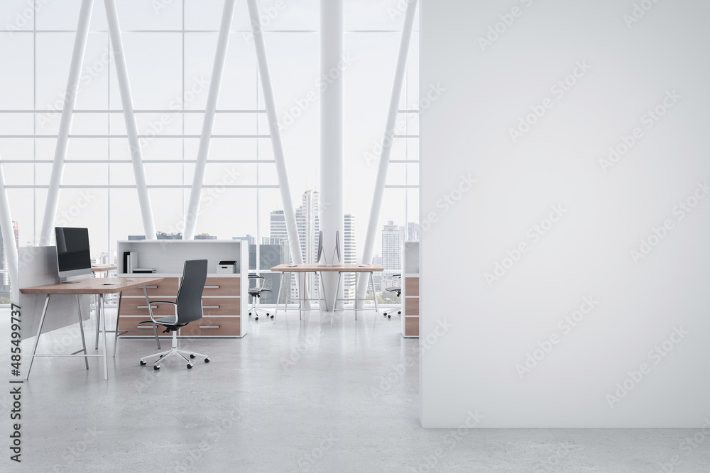 现代宽敞办公室前景中的空白白墙，配有木质细节的工作空间，现代