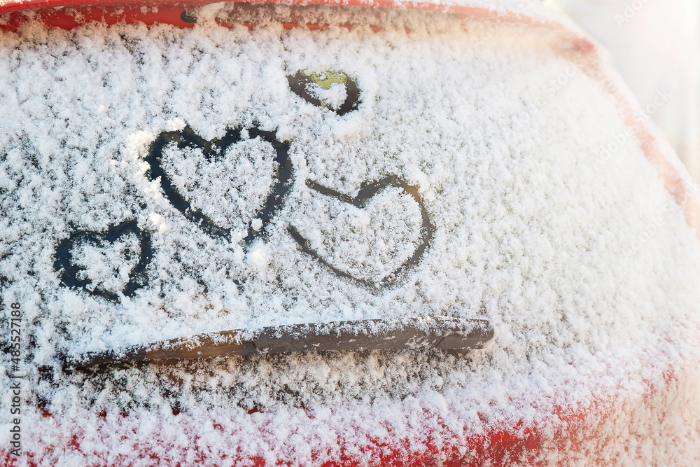 四颗心（爱的象征）与sunli在汽车挡风玻璃雨刮器上方的雪地上手绘（画）