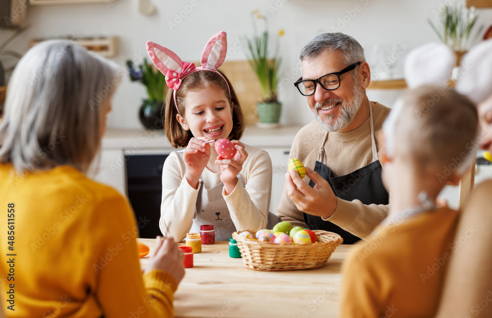 幸福的家庭祖父和小孙女拿着装满彩绘煮鸡蛋的柳条篮子