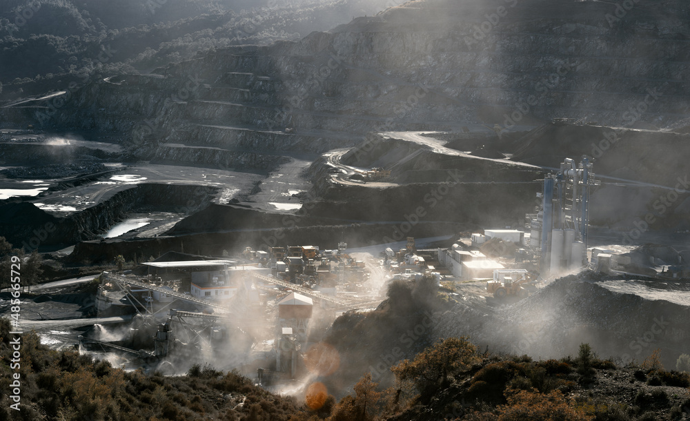 采石场的采矿厂在生产的尘埃云中，背光下的戏剧性景观与太阳同在