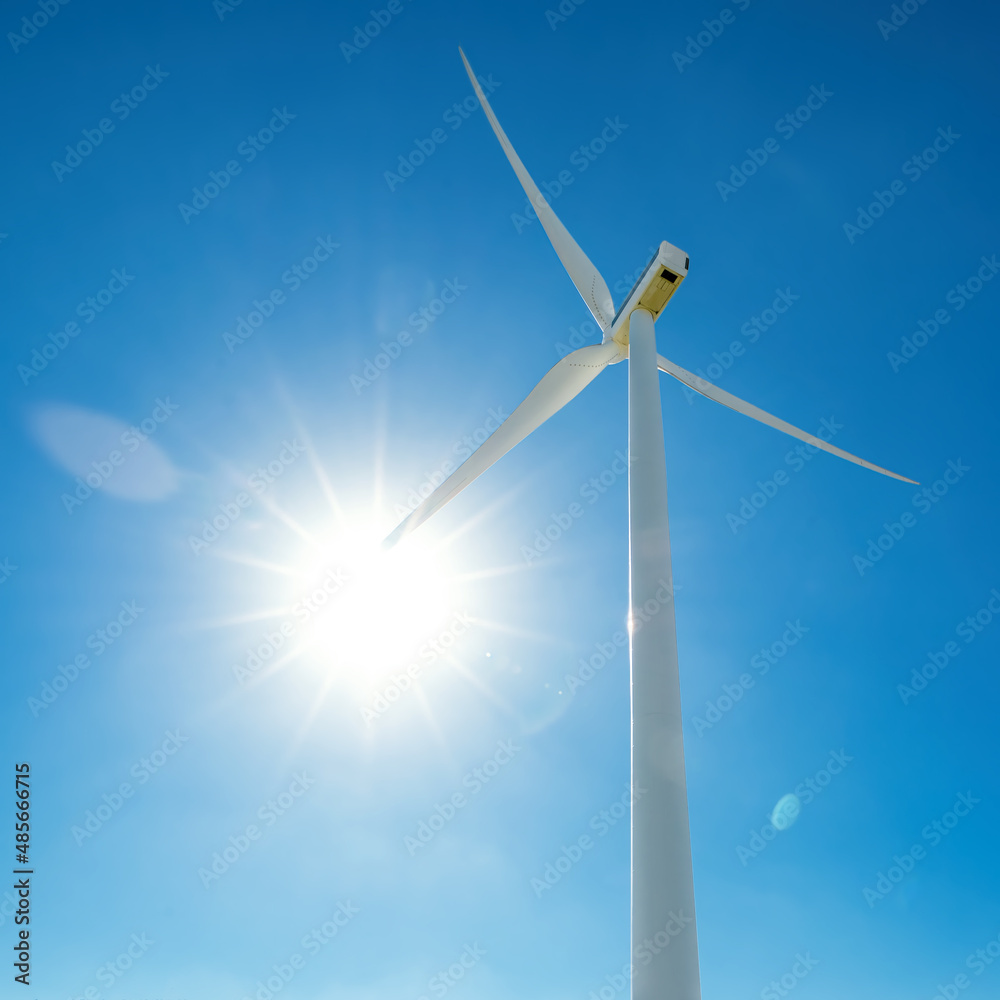 阳光照射下的风力涡轮机叶片，蓝天，透镜光斑