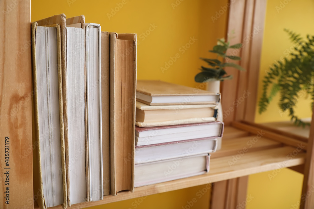 黄色墙壁附近的木制书架，特写