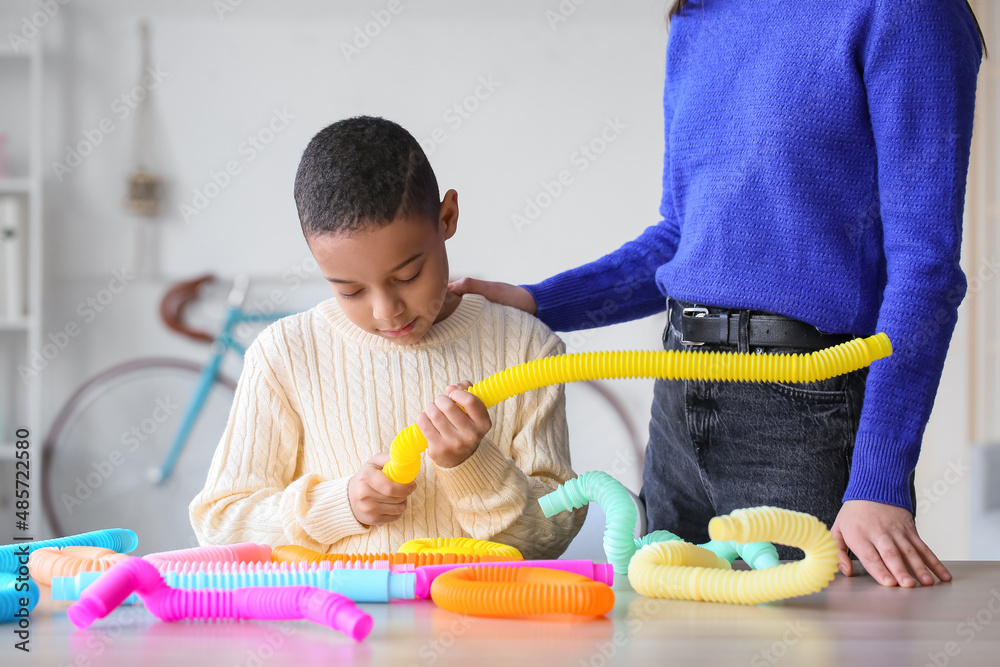 非洲裔美国小男孩和他的妈妈在家玩Pop Tubes