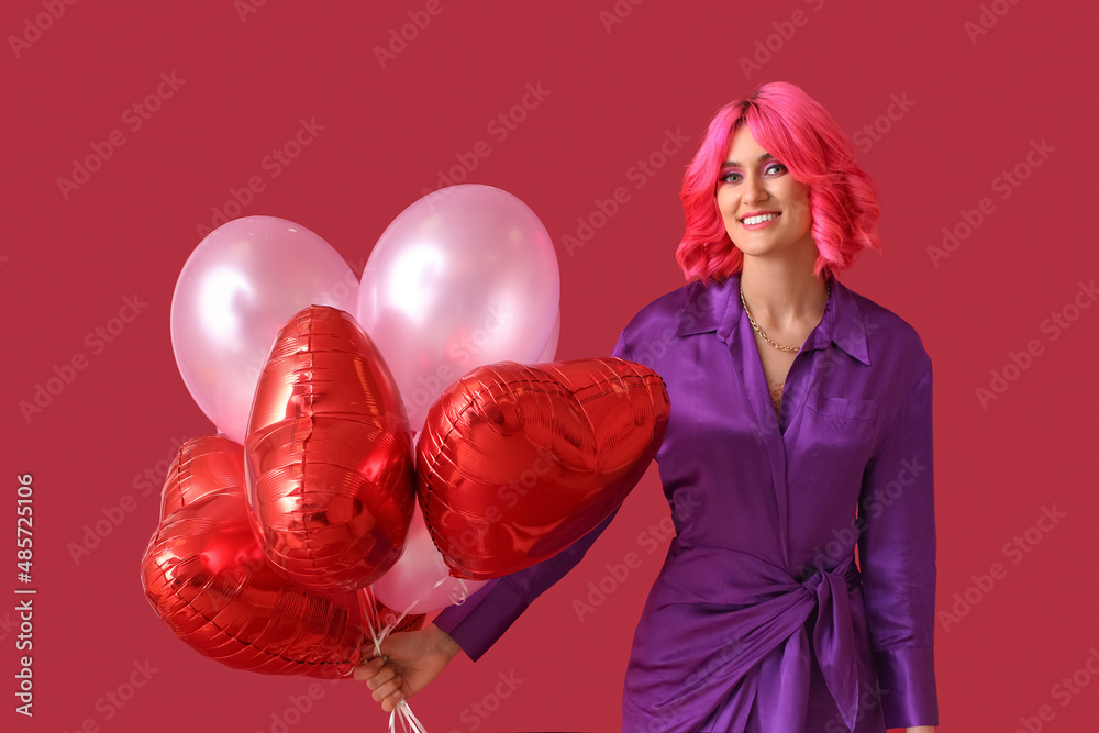 有着明亮头发和彩色背景气球的时尚女性。情人节庆祝活动