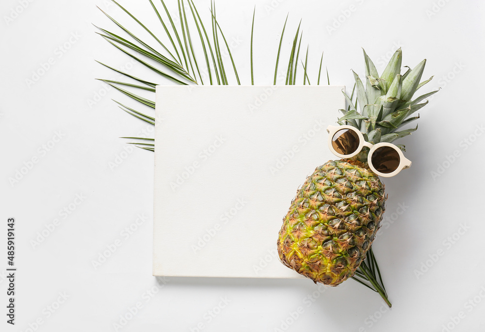 白色背景上有空白海报、菠萝、太阳镜和棕榈叶的构图