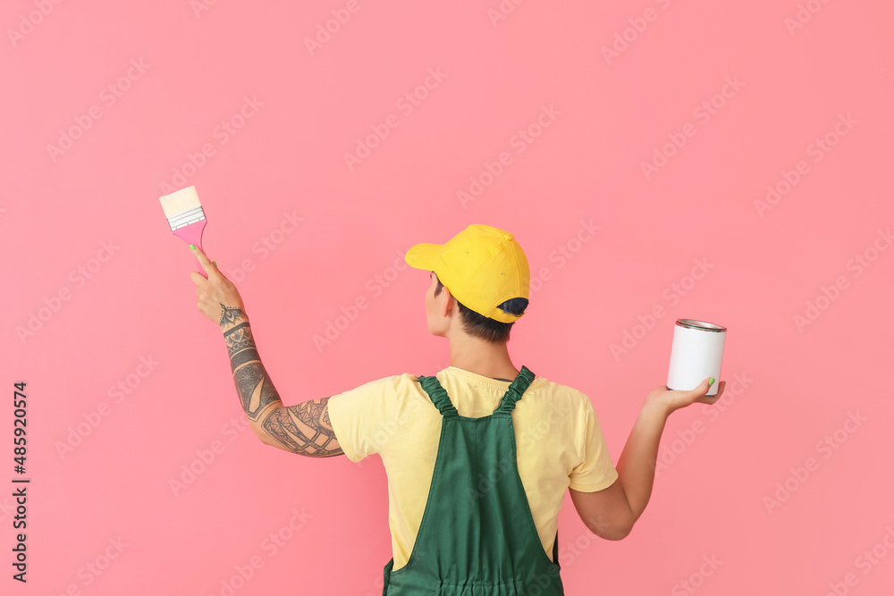 粉色背景上戴着刷子和罐子的女画家