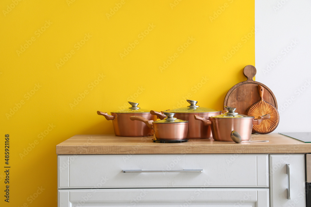 彩色墙附近桌子上的不同厨具、勺子和木板