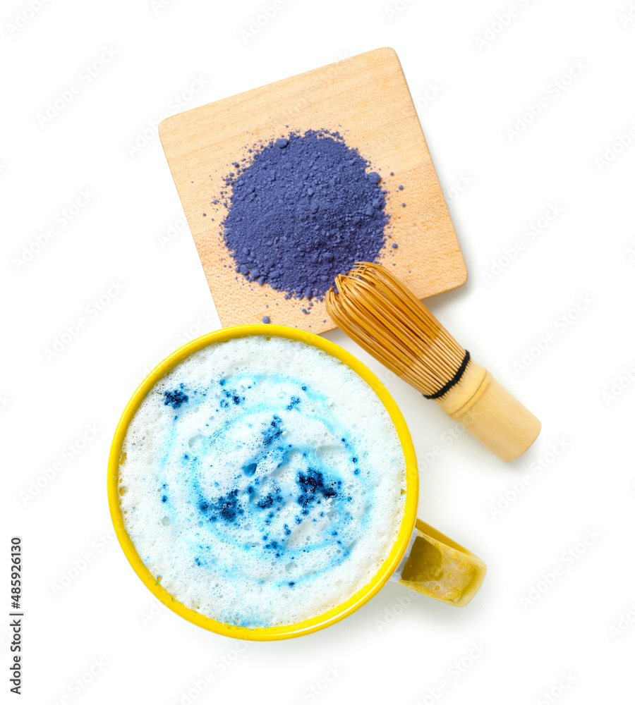 Cup of tasty blue matcha latte, chasen and powder on white background