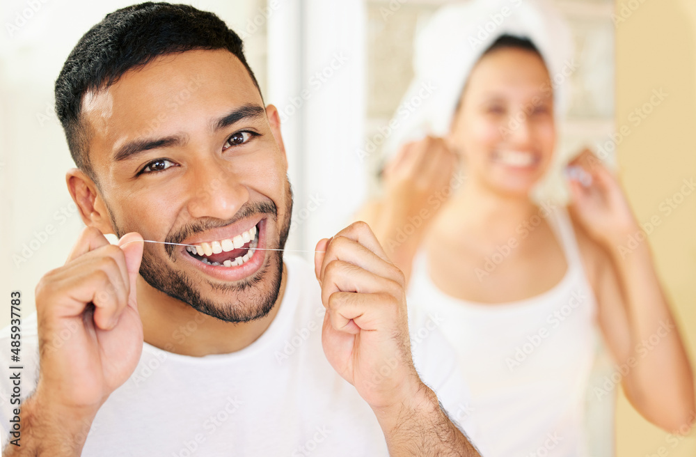 Flossing is just as important as brushing your teeth. Shot of a happy young couple flossing their te