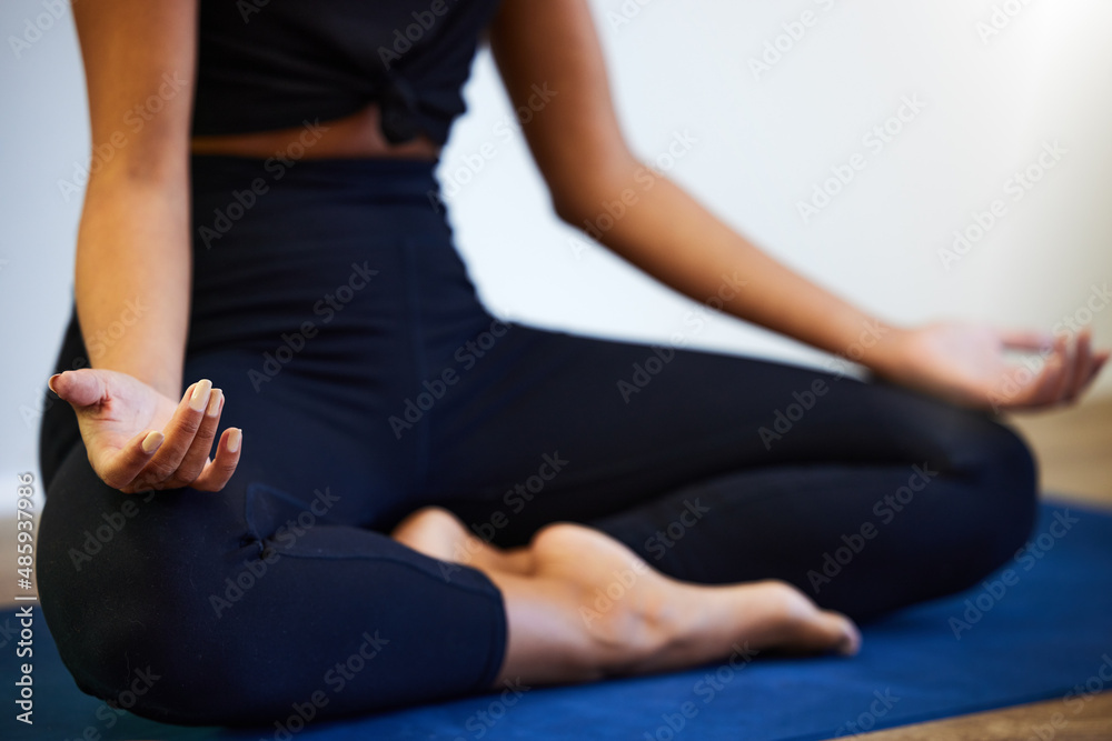压力越小，流量越大。一张年轻女子坐在家里的瑜伽垫上冥想的照片。
