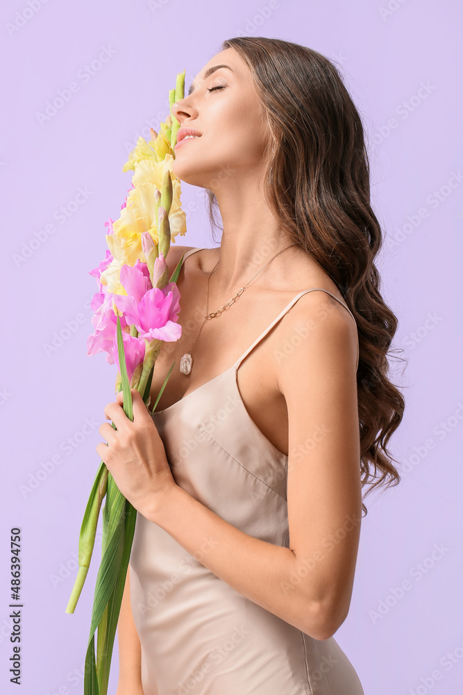 闭着眼睛的年轻女子拿着一束美丽的唐菖蒲花，背景是彩色的