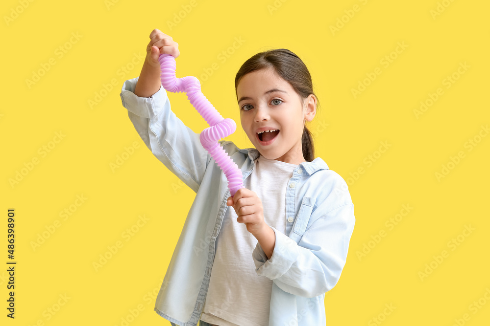 Little girl with lilac Pop Tube on yellow background