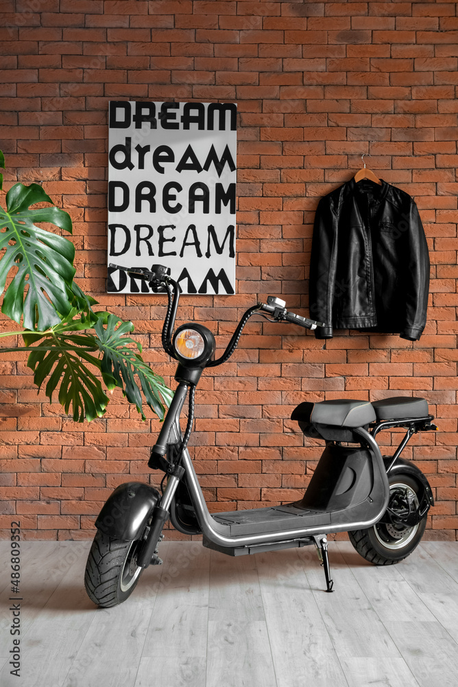 Stylish interior of room with modern scooter, leather jacket and brick wall